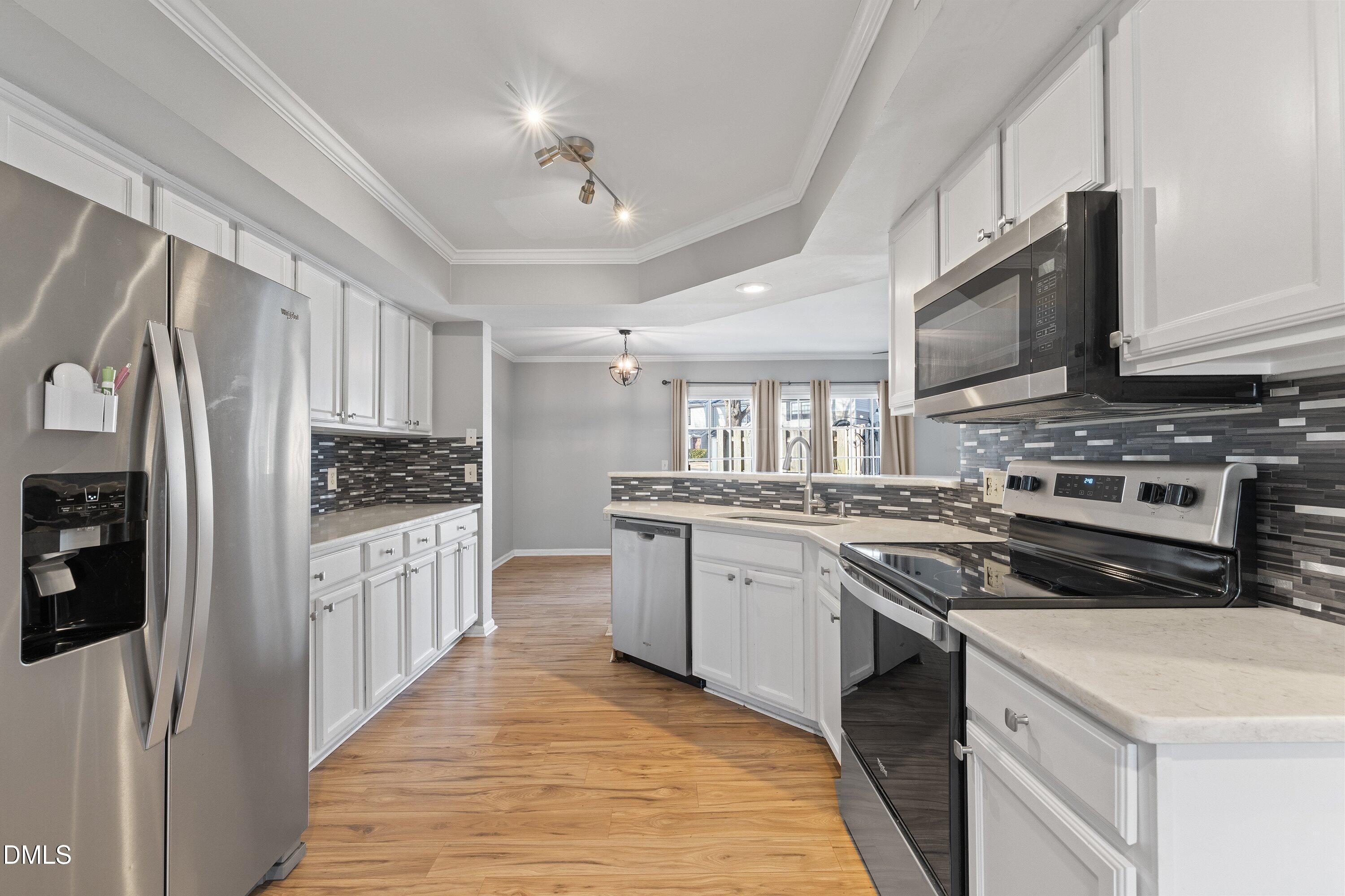 2400 Condor Court Raleigh, NC 27615 - Photo 9 of 40 a kitchen with stainless steel appliances granite countertop a stove top oven a refrigerator a sink and dishwasher