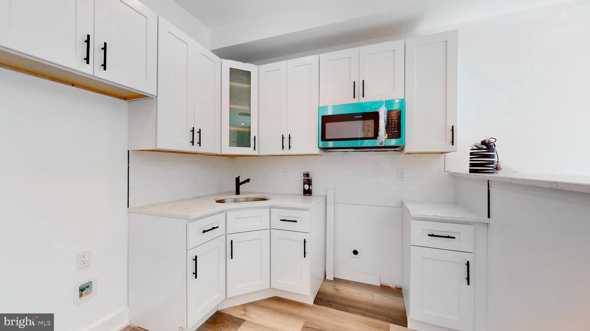 651 North 16th Street, Unit 2 Philadelphia, PA 19130 - Photo 5 of 19 a kitchen with white cabinets and black appliances