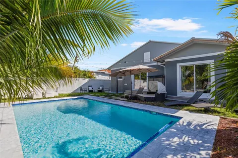 a view of a house with backyard and sitting area