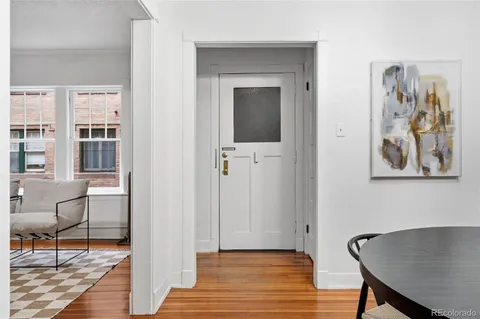 a view of a hallway with wooden floor and a bookshelf