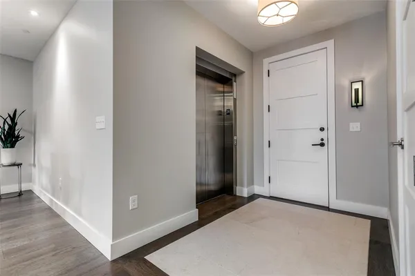 an empty room with wooden floor closet and windows