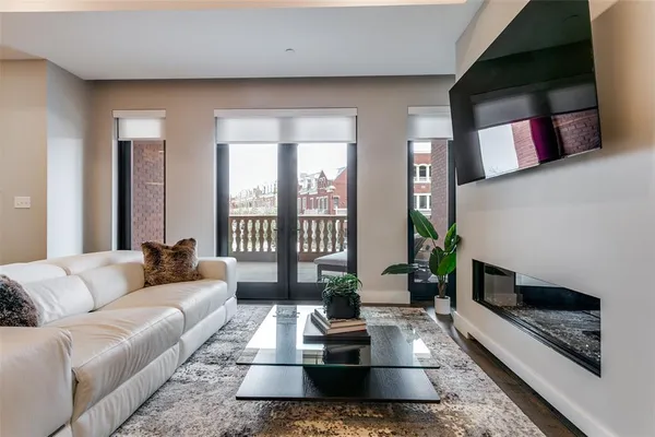 a living room with furniture fireplace and a floor to ceiling window