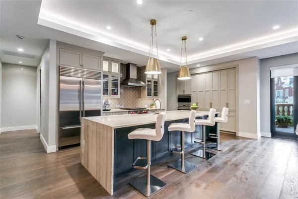 a kitchen with kitchen island a dining table chairs refrigerator and a sink