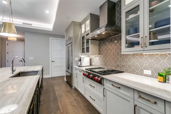 a kitchen with stainless steel appliances a sink a stove and cabinets
