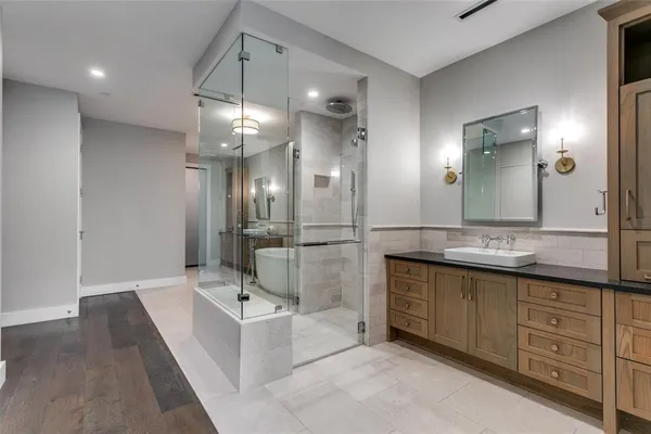 a bathroom with a tub sink shower and mirror