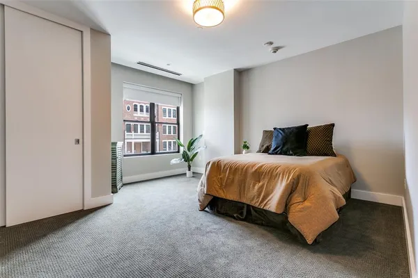a spacious bedroom with a bed and a window