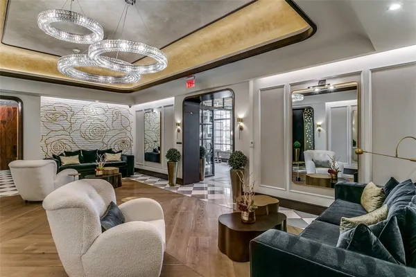 a living room with furniture chandelier and a large window