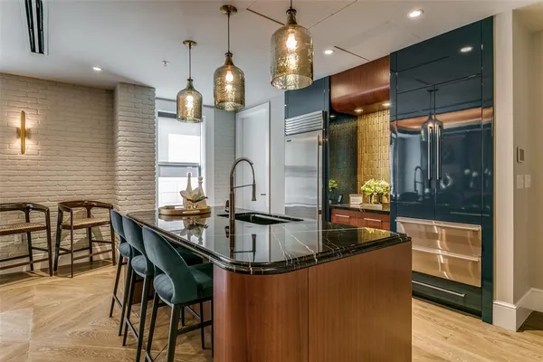 a kitchen with kitchen island granite countertop a table chairs sink and window