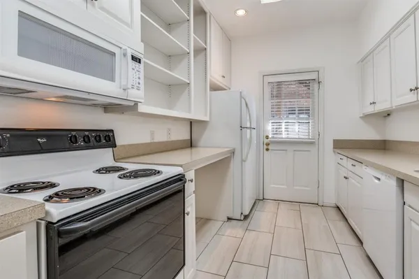 a kitchen with white cabinets and appliances