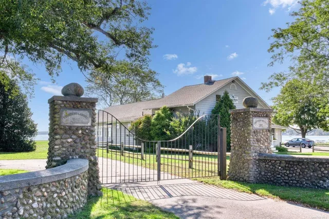 a view of a house with a small yard and a large tree