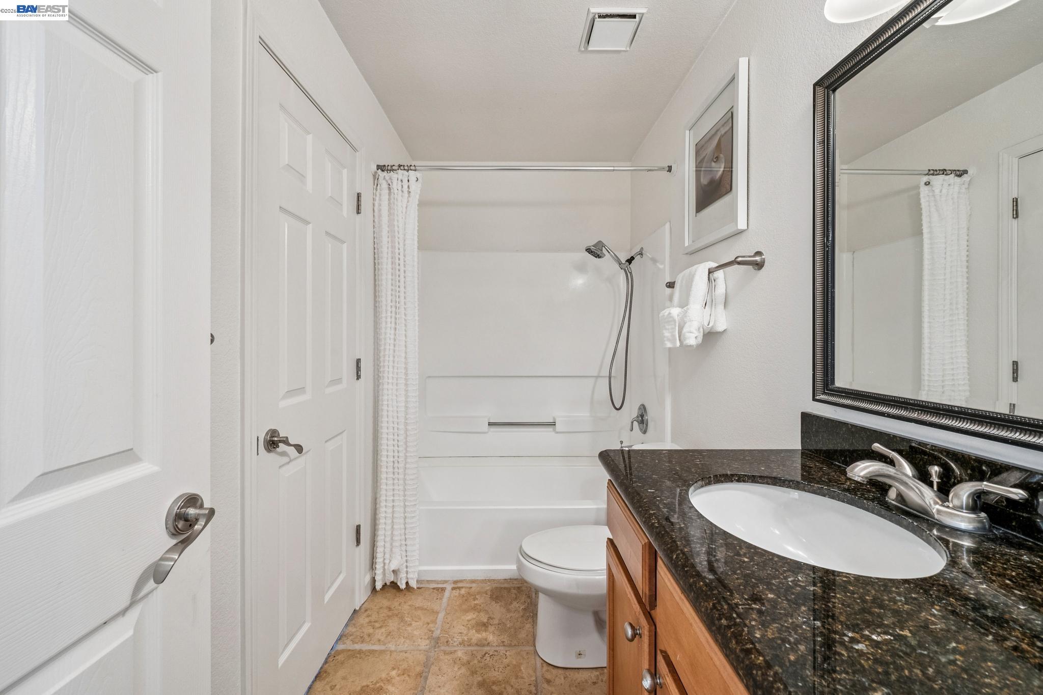 182 Eastridge Drive San Ramon, CA 94582 - Photo 31 of 54 a bathroom with a granite countertop sink toilet a shower and a mirror