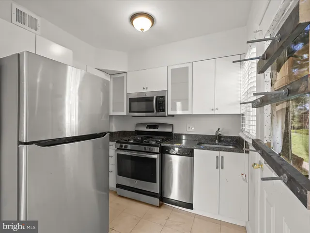 a kitchen with stainless steel appliances a refrigerator a stove a microwave and cabinets