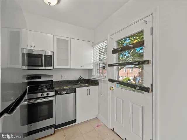 a kitchen with stainless steel appliances a stove microwave and sink