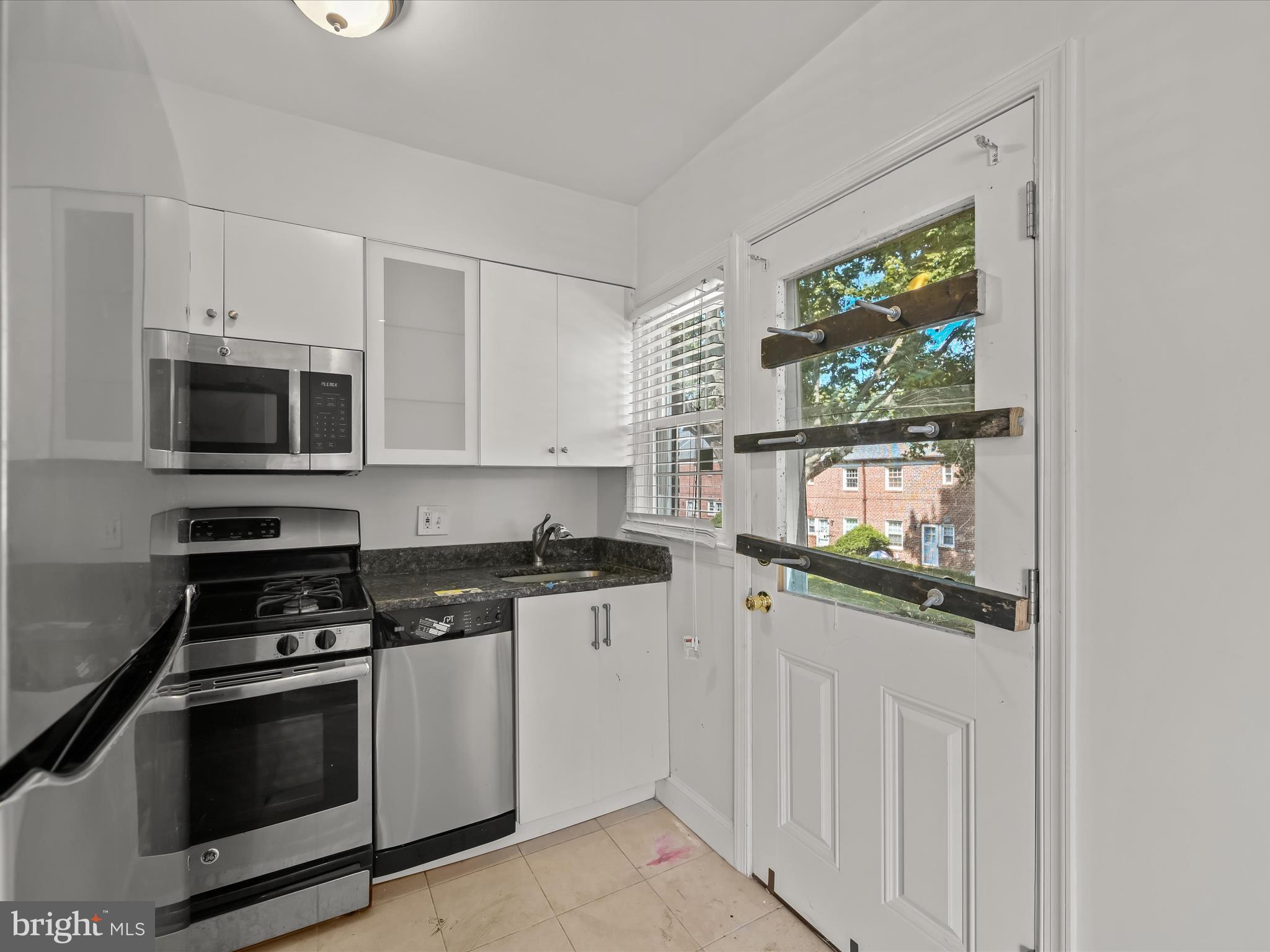 1776 East W Highway, Unit 1776 Silver Spring, MD 20910 - Photo 12 of 31 a kitchen with stainless steel appliances a stove microwave and sink