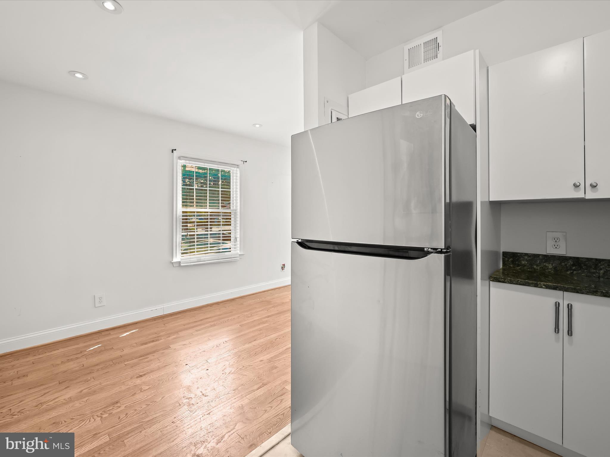 1776 East W Highway, Unit 1776 Silver Spring, MD 20910 - Photo 13 of 31 a kitchen with granite countertop a refrigerator and a stove top oven