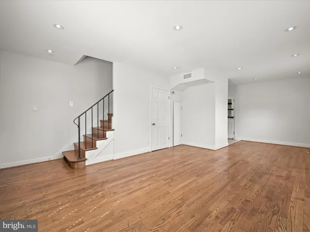 a view of empty room with wooden floor