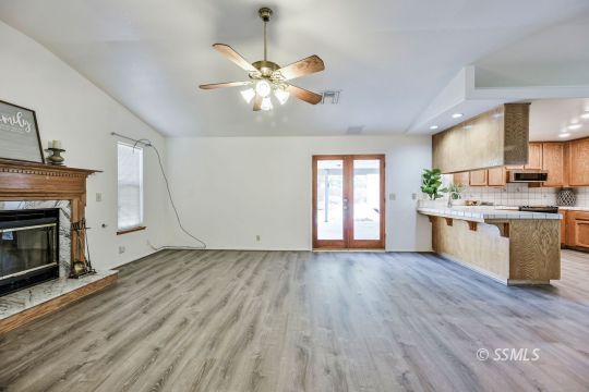 1213 Alysa Court Ridgecrest, CA 93555 - Photo 8 of 34 a kitchen with stainless steel appliances granite countertop a stove top oven a sink dishwasher and a fireplace with wooden floor