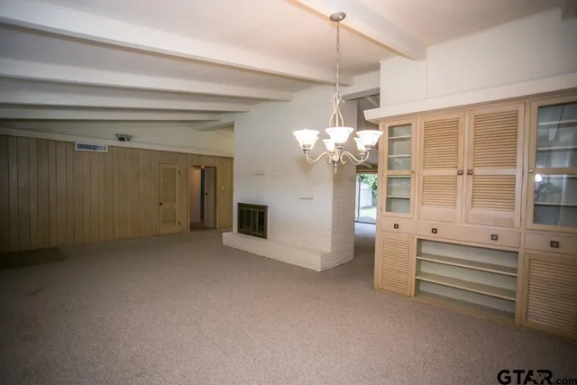 wooden floor with chandelier and entryway