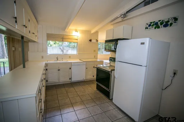 a kitchen with a refrigerator sink stove and cabinets