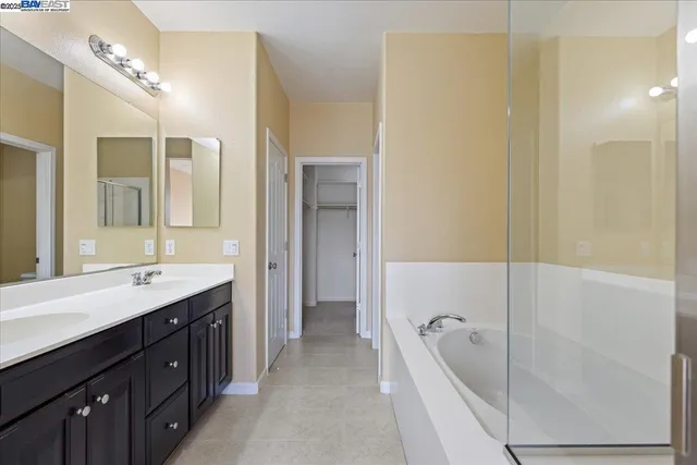 a spacious bathroom with a tub sink shower and mirror