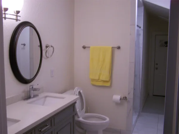a bathroom with a granite countertop sink and a mirror
