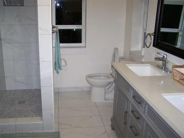 a bathroom with a sink a toilet and shower