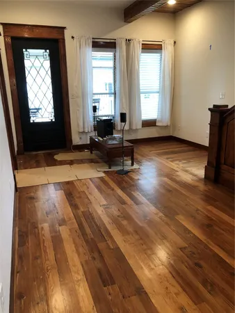 a living room with hardwood floor and a window