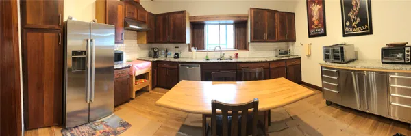a large kitchen with kitchen island wooden cabinets and stainless steel appliances