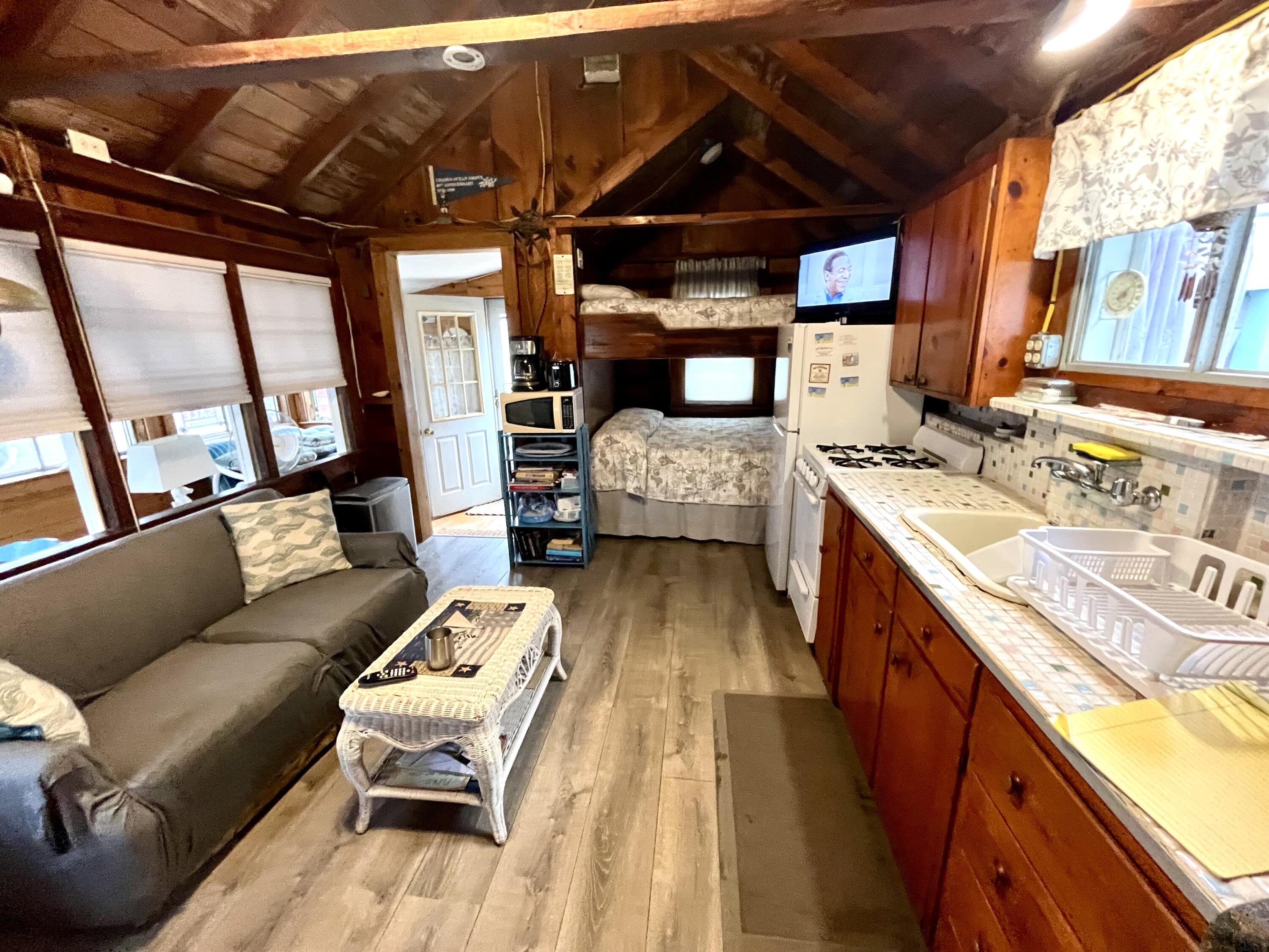 217 Old Wharf Road, Unit 64 Dennis Port, MA 02639 - Photo 7 of 16 a view of living room kitchen with furniture and fireplace