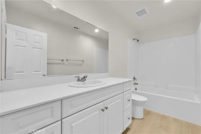 a bathroom with a sink toilet vanity and bathtub