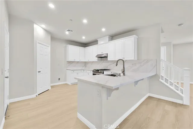 a kitchen with stainless steel appliances a sink stove and cabinets