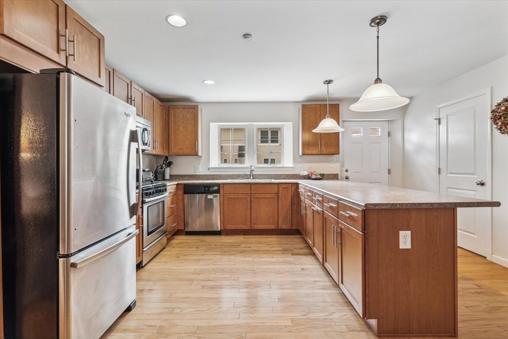 6 Bates Street, Unit B Devens, MA 01434 - Photo 3 of 30 a large kitchen with stainless steel appliances granite countertop a sink refrigerator and cabinets