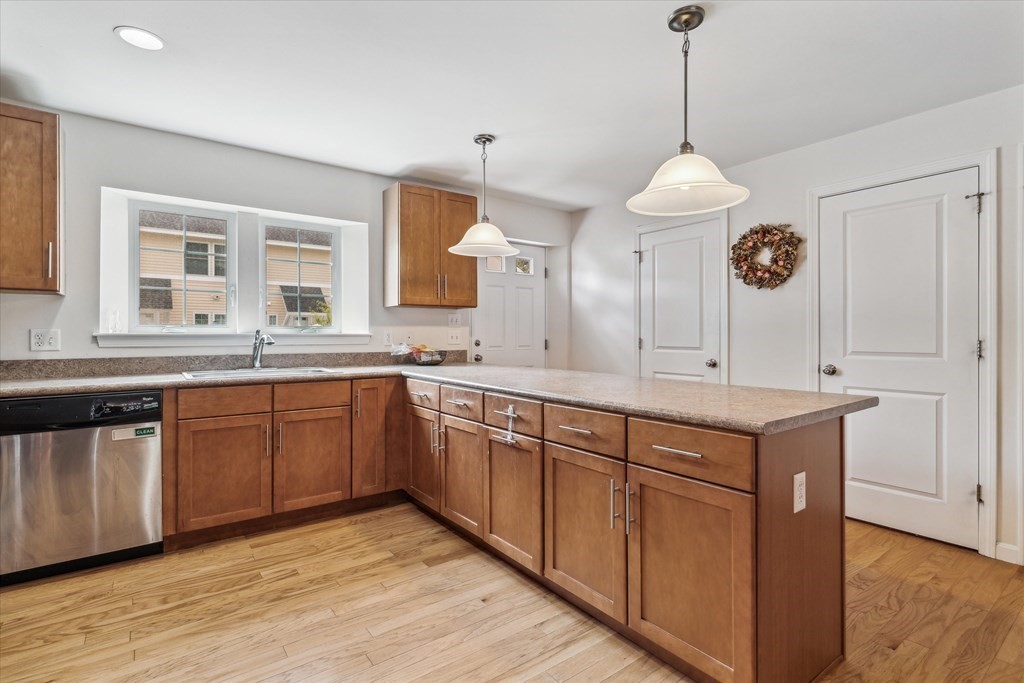6 Bates Street, Unit B Devens, MA 01434 - Photo 4 of 30 a kitchen with a sink stove and wooden cabinets
