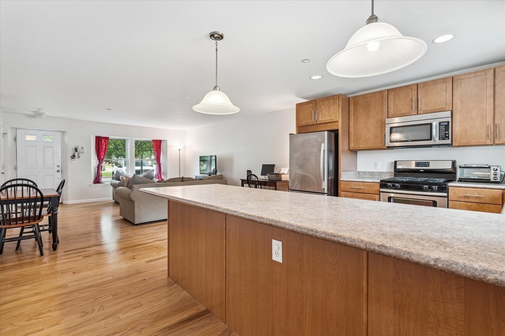 6 Bates Street, Unit B Devens, MA 01434 - Photo 6 of 30 a kitchen with stainless steel appliances granite countertop a sink refrigerator and cabinets