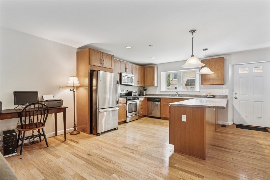 6 Bates Street, Unit B Devens, MA 01434 - Photo 8 of 30 a kitchen with kitchen island a counter top space a sink stainless steel appliances and cabinets