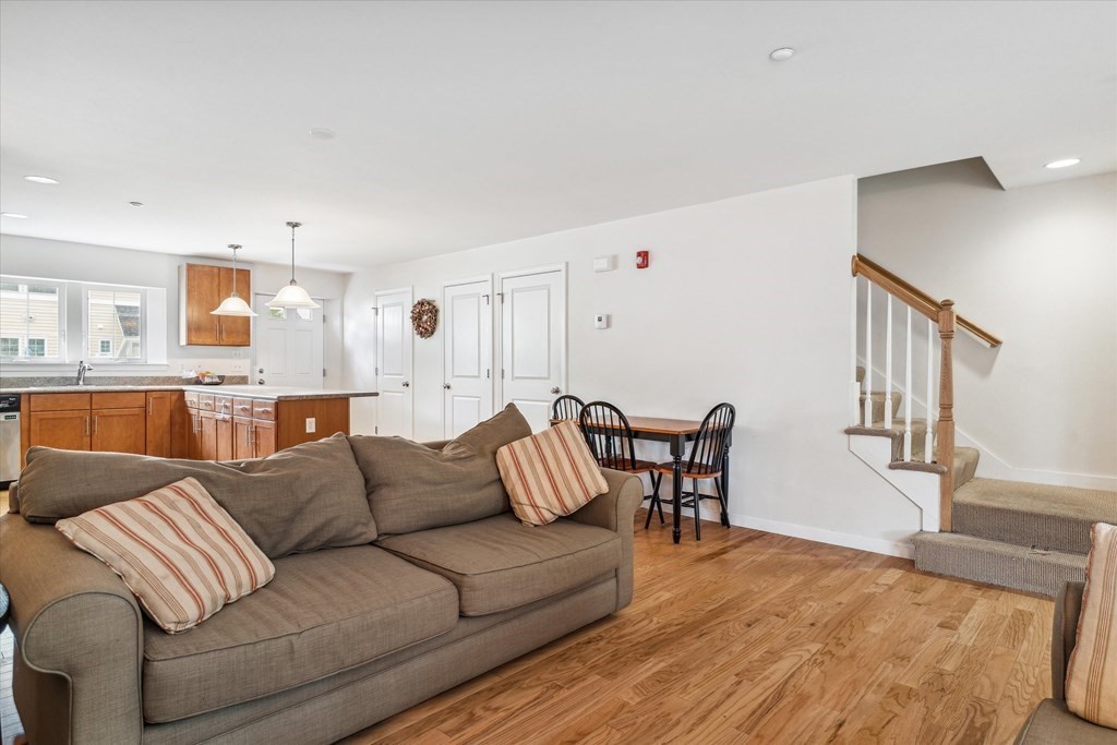 6 Bates Street, Unit B Devens, MA 01434 - Photo 9 of 30 a living room with furniture and a dining table with wooden floor