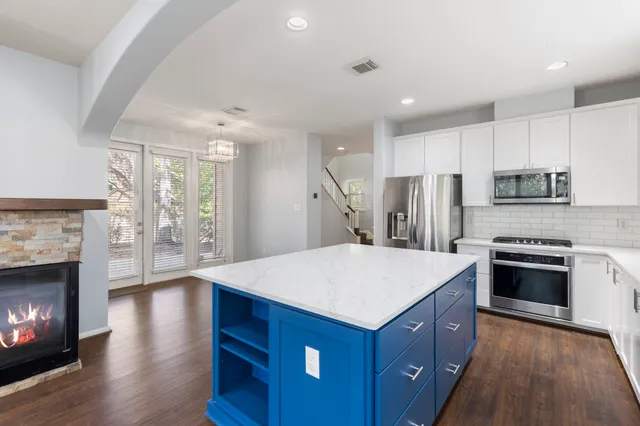 a kitchen with kitchen island a sink appliances and cabinets