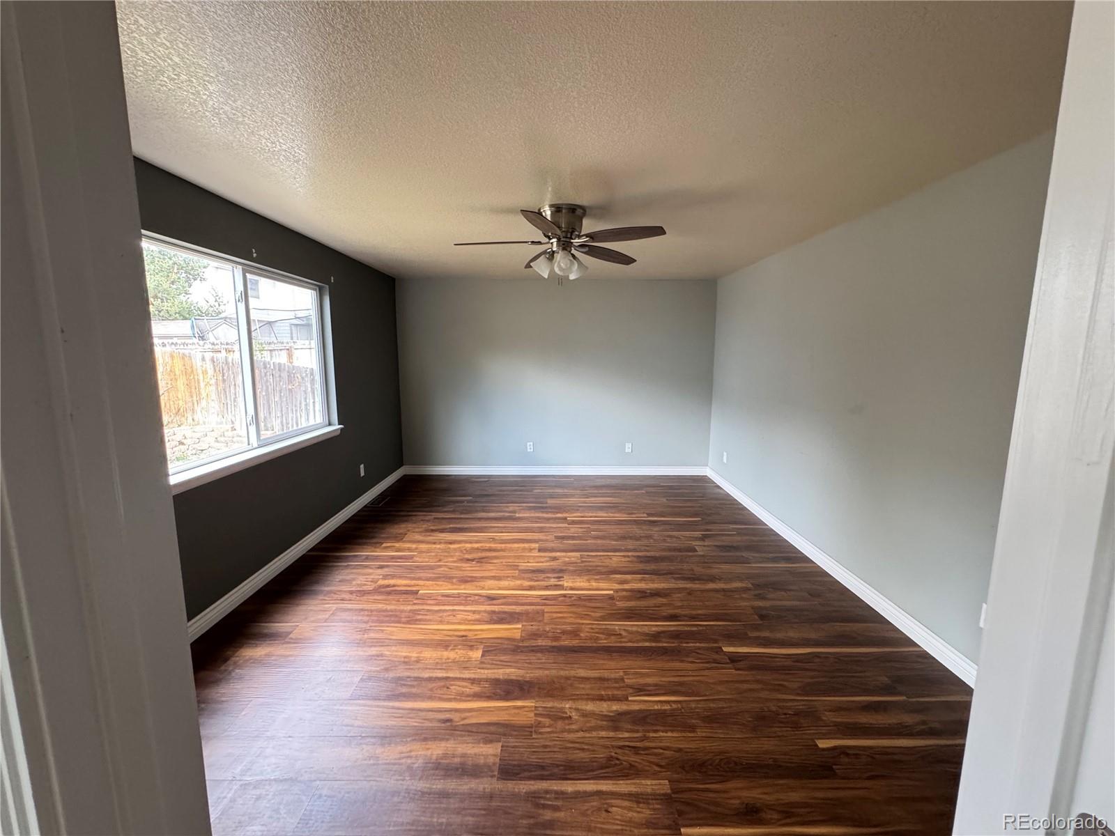 3461 Maple Circle Brighton, CO 80601 - Photo 14 of 27 wooden floor in an empty room with a window