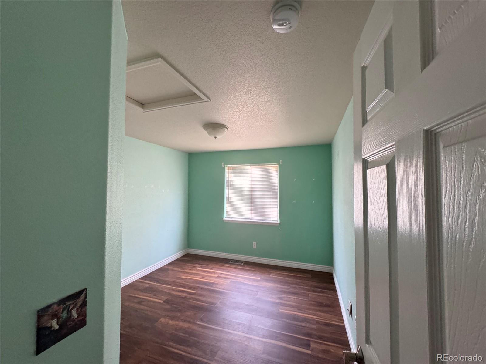 3461 Maple Circle Brighton, CO 80601 - Photo 18 of 27 an empty room with wooden floor and windows