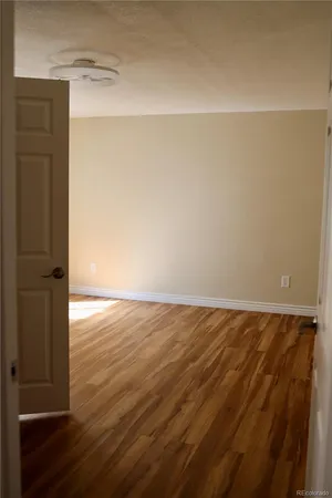 an empty room with wooden floor and closet