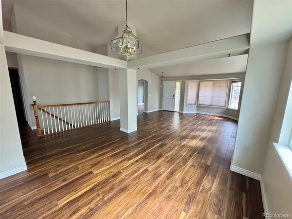 a view of a room with wooden floor staircase and a kitchen