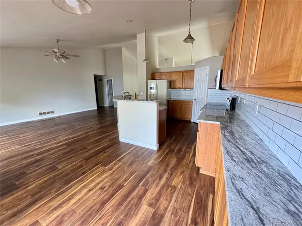 a view of a kitchen with wooden floor and a sink
