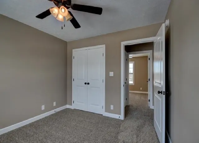 an empty room and chandelier fan