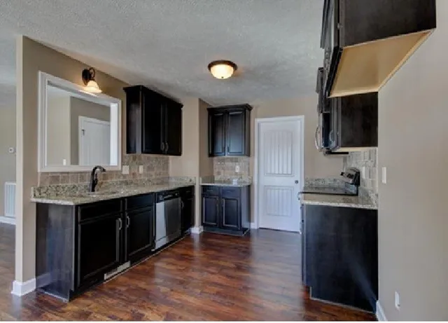 a kitchen with stainless steel appliances granite countertop a sink and stove top oven