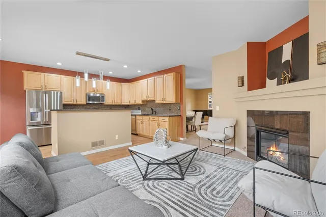 a kitchen with stainless steel appliances granite countertop a sink a stove a refrigerator and cabinets