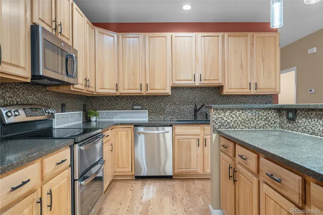 a kitchen with stainless steel appliances granite countertop a stove and a refrigerator