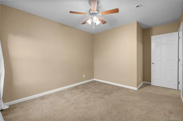 a view of an empty room with wooden floor and windows