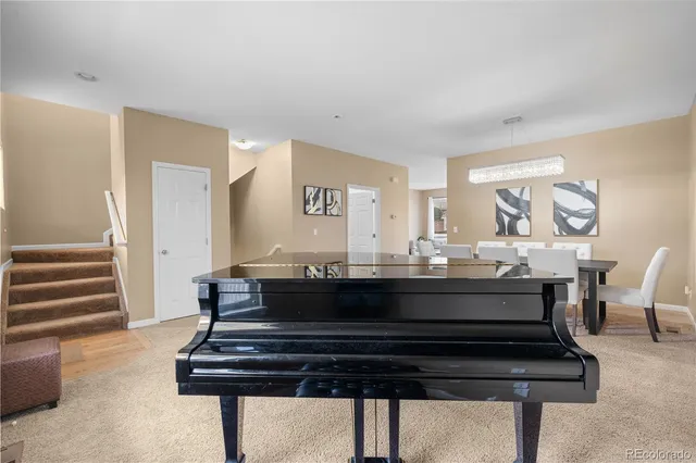 a living room with furniture and a piano