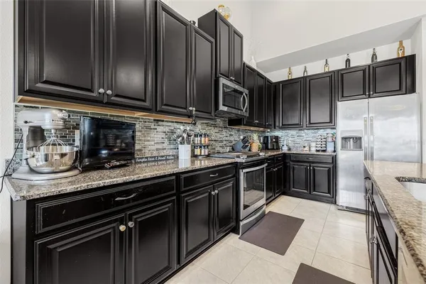 a kitchen with granite countertop a stove sink and cabinets