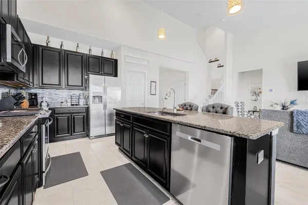 a kitchen with stainless steel appliances granite countertop a sink a stove and a refrigerator
